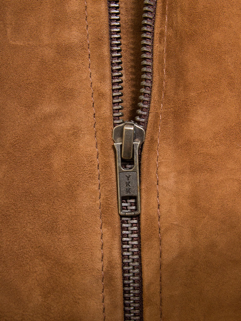 Close-up of a brown leather bag with a silver zipper